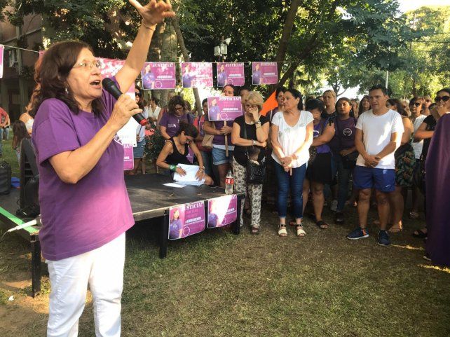 Liliana Loyola dando las palabras iniciales en el acto de pedido de justicia por Daniela Cejas. Javier Sen, con remera blanca y shorts cortos azules, escuchando el discurso de pedido de esclarecimiento de la muerte y de justicia.