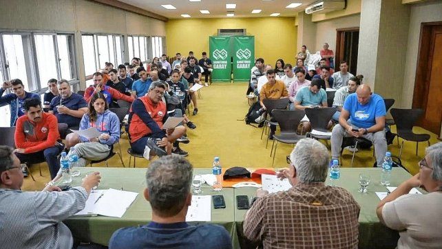Los nadadores escuchan atentamente las disposiciones del comité organizador en la previa a la competencia.
