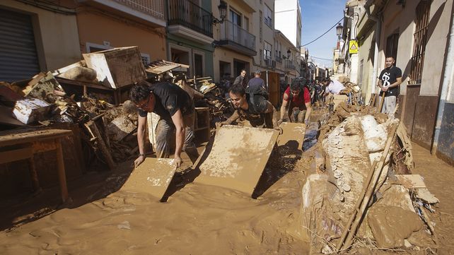 Residentes y voluntarios intentan retirar el barro en una zona afectada por las inundaciones en Paiporta, cerca de Valencia, España, el viernes 1 de noviembre de 2024. (Foto AP/Alberto Saiz)