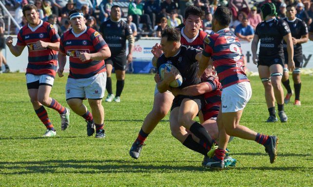Cuero Benítez, capitán y referente de Universitario intenta zafar de la múltiple marca del equipo Cangrejo.