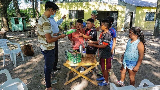 Atahualpa Larrea entregando juegos de ajedrez a nenes y nenas del barrio donde aún vive, a pesar de la inundación de 2003.