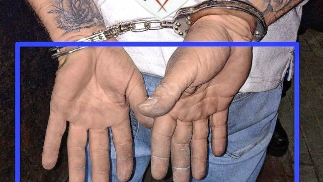 Hollín en las manos de uno de los detenidos por los autos incendiados en Rosario.