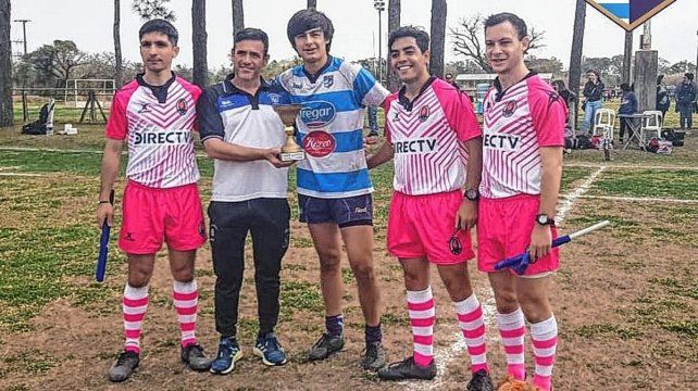 El vicepresidente de la USR, Alberto Pelossi (h), entregando la respectiva al capitán de la M16 de CRAI que se consagró campeón del certamen oficial.