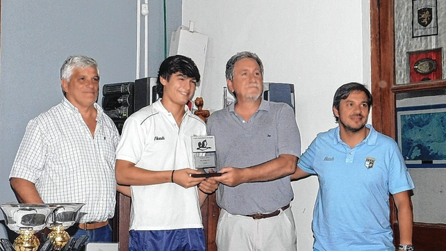 El coach Pablo Martegani y el capit&aacute;n de CRAI reciben del dirigente Esteban Gastaldi, el presente por haber sido campeones en M17.
