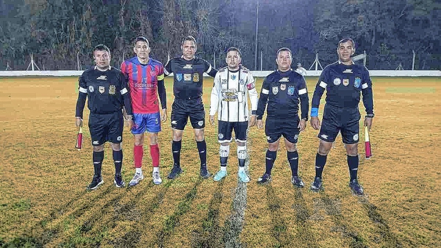 &nbsp;El &aacute;rbitro Carlos C&oacute;rdoba junto a los capitanes en la noche fr&iacute;a del predio Nery Pumpido.