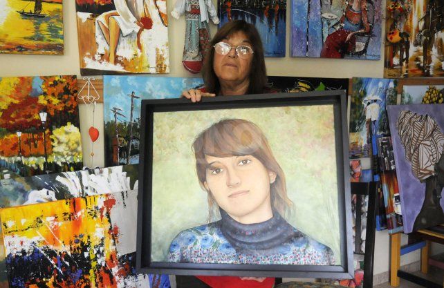 Graciela Brondino junto a la pintura de su hija Marianela. 