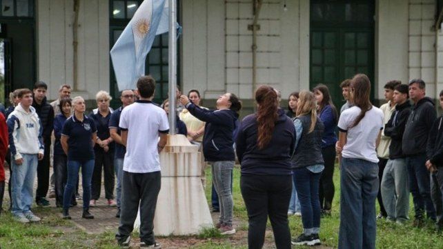 El reducido grupo escolar que regresó a la Mariano Moreno en el primera izamiento de la bandera después del tiroteo fatal.